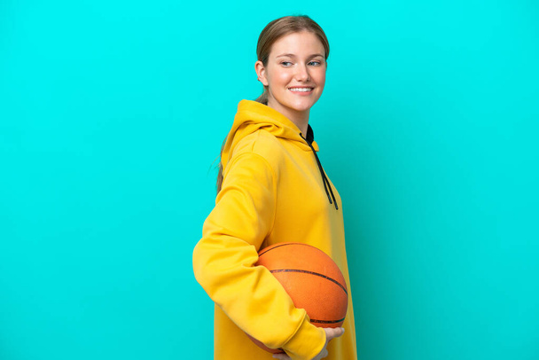 Young caucasian woman isolated on blue background playing basketball - Foto, Imagem