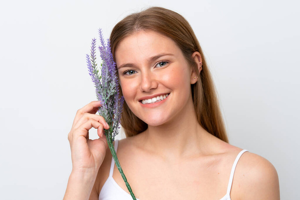 Young caucasian woman isolated on white background holding a lavender plant. Close up portrait - Photo, Image