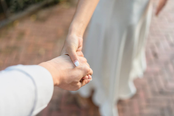 Sposo che si tiene per mano con amore il giorno del matrimonio - Foto, immagini