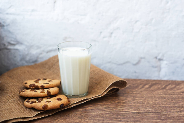 Geurige, smakelijke, zelfgemaakte koekjes met rozijnen en een glas verse melk op tafel. Heerlijk, hartig, gezond ontbijt. Kopieer ruimte, hoge resolutie - Foto, afbeelding