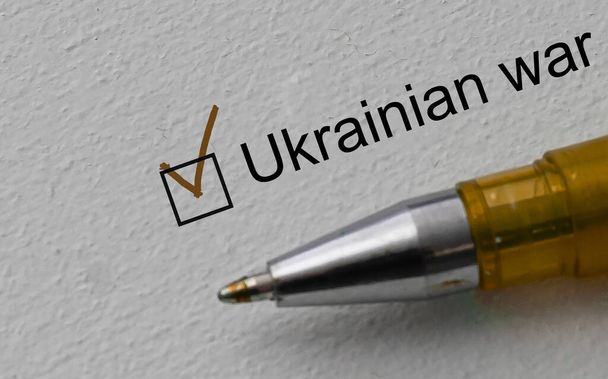 marca de verificación en la palabra guerra ucraniana y pluma. Primer plano, concepto - Foto, imagen