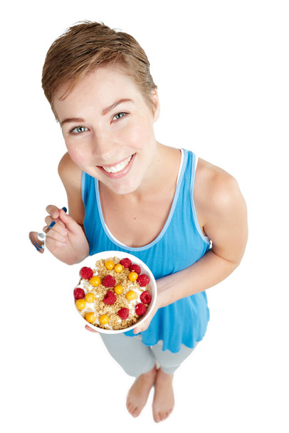 Eat healthy and be happy. Studio portrait of a young woman enjoying a muesli and yoghurt treat. - Photo, image