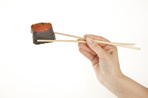 Kezében pálcika, elszigetelt fehér sushi tekercs - Fotó, kép