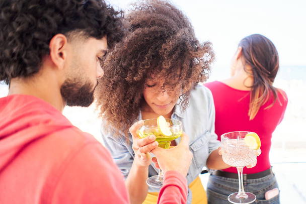 Multiraciaal jong stel Vrienden juichen samen toasten cocktails op het dak. Het concept van het sociale gemeenschapsleven - Foto, afbeelding