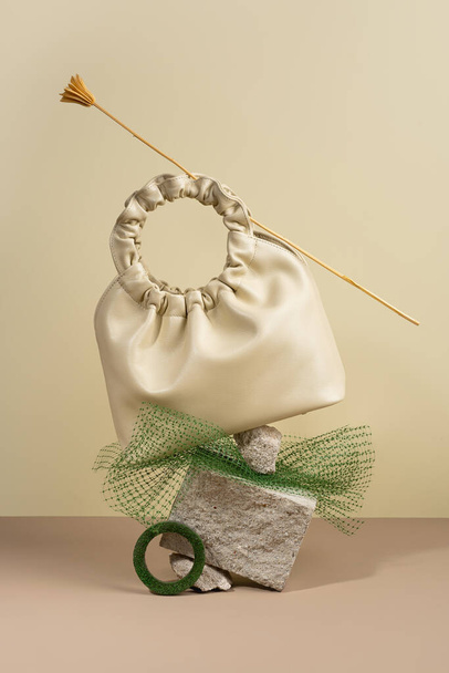 Современный креативный натюрморт, сбалансированная сумка из искусственной кожи на минималистичном фоне.. - Фото, изображение