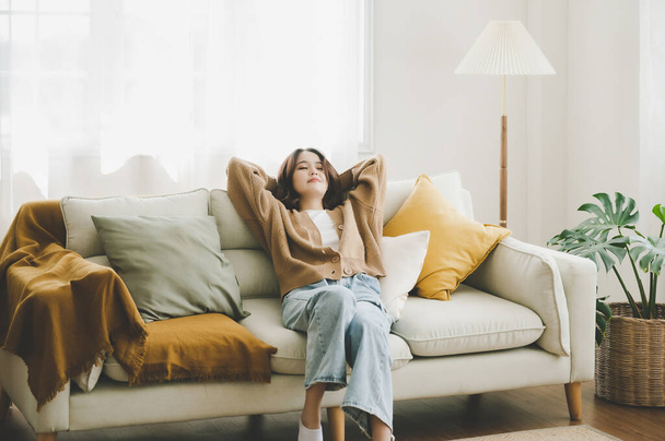 Šťastná asijská žena relaxace na pohodlné měkké pohovce těší stresu volný víkend doma, Ona protahuje na gauči myšlení na příjemný líný den - Fotografie, Obrázek