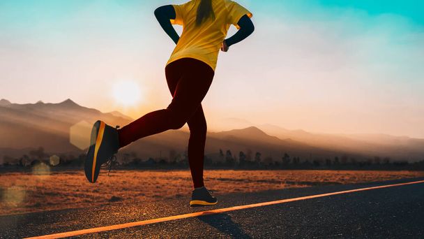 Jonge fitnessvrouw is hardlopen en joggen een outdoor workout op het platteland in de ochtend voor levensstijl gezondheid. - Foto, afbeelding