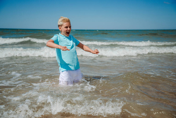 Мальчик-подросток плескается в море - Фото, изображение