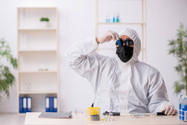 Young male chemist working at the lab during pandemic - Foto, immagini