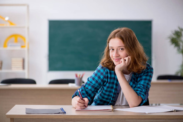 Junge Studentin bereitet sich im Klassenzimmer auf Prüfung vor - Foto, Bild