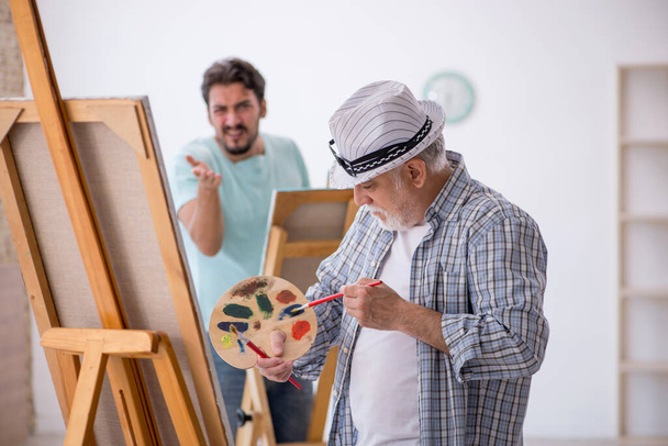 Dos pintores masculinos disfrutando pintando en casa - Foto, Imagen