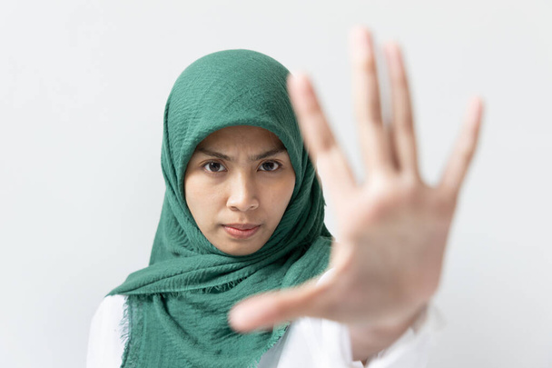 Nowoczesna muzułmanka z gestem stop hand, powstrzymać azjatycką nienawiść lub powstrzymać muzułmańską nienawiść lub inkluzywność i koncepcję różnorodności - Zdjęcie, obraz