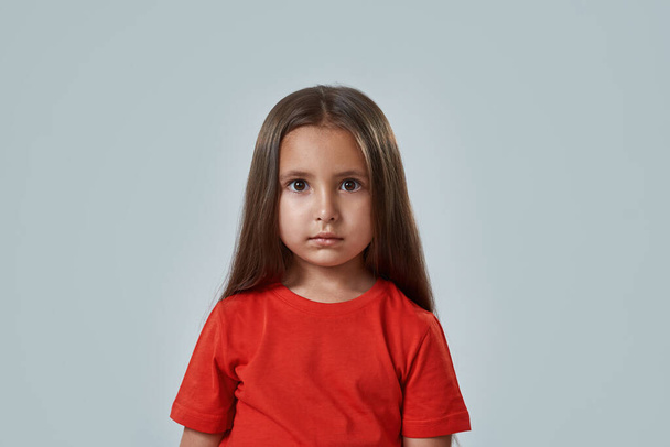 Cropped of concentrated little girl look at camera - 写真・画像