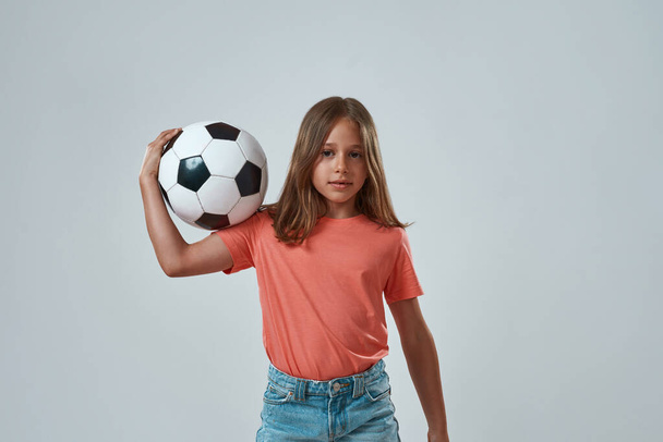 Front view of little girl holding football ball - 写真・画像