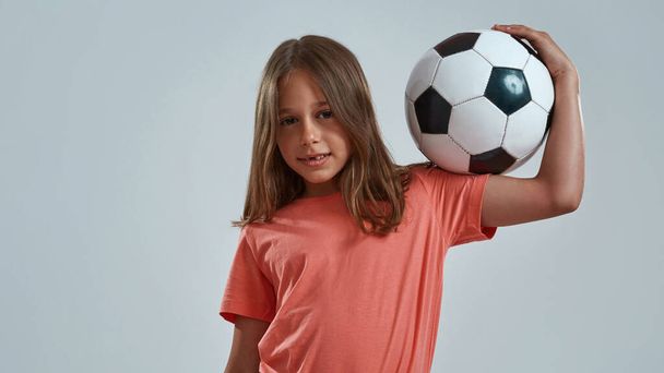 Partial of smiling little girl hold football ball - Foto, imagen
