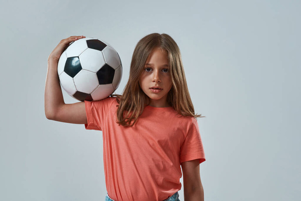 Little girl hold football ball and look at camera - 写真・画像