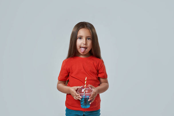 Little girl licking lips after drinking soda drink - Foto, afbeelding