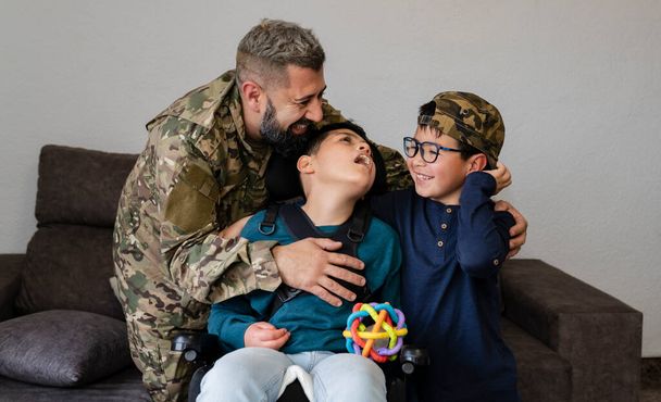 Στρατιωτικός πατέρας με τα δύο παιδιά του να χαμογελούν, ένας στρατιώτης που επιστρέφει αγκαλιάζοντας τα παιδιά του στο σπίτι - ανάπηρο παιδί - - Φωτογραφία, εικόνα