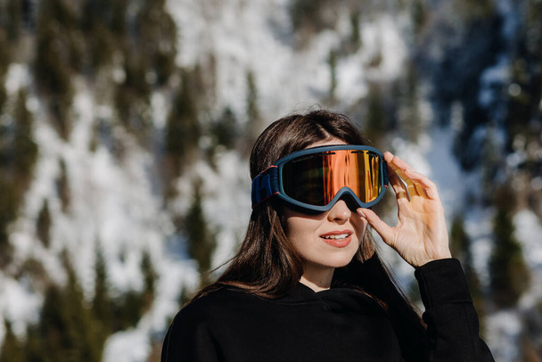 Ritratto di una ragazza felice con gli occhiali da sci su un bellissimo sfondo di montagne. Primo piano. Foto di alta qualità - Foto, immagini
