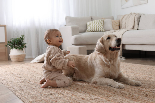 Cute little baby with adorable dog on floor at home - Fotografie, Obrázek