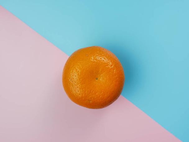Creative concept made from orange on blue and pink pastel background. healthy and minimal fruit concept - Zdjęcie, obraz