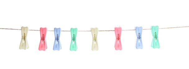 Plastic clothes pins hanging on rope against white background - Photo, Image