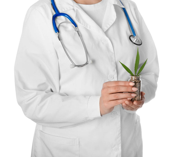 Жінка-лікар з насінням конопель у пляшці на білому тлі, крупним планом
 - Фото, зображення
