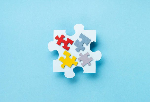 World Autism Awareness Day or month concept. Creative design for April 2. Color puzzle, symbol of awareness for autism spectrum disorder on blue background. Top view, copy space. - Photo, Image