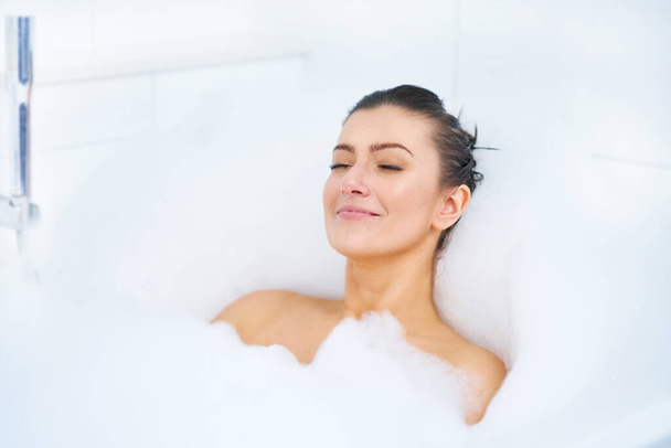 Young nice brunette woman having bath in bathtub - Zdjęcie, obraz