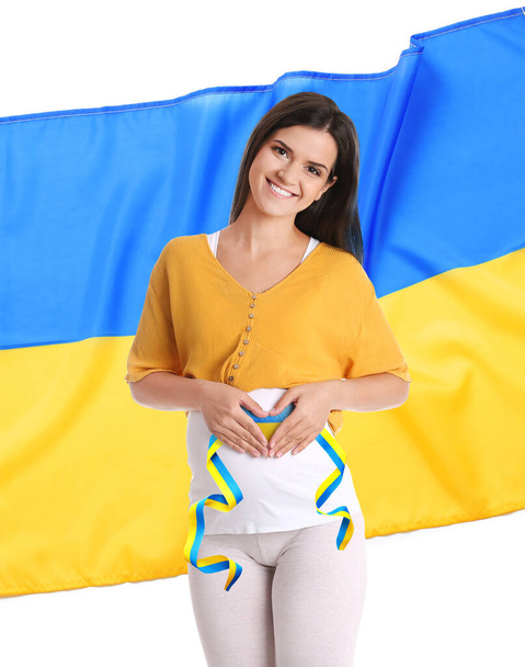 Pregnant woman and Ukrainian flag on white background. Stop war - Фото, изображение