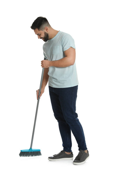 Young man with broom on white background - Fotografie, Obrázek