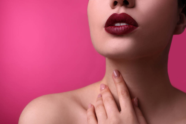 Closeup view of woman with beautiful full lips on pink background, space for text - Foto, immagini