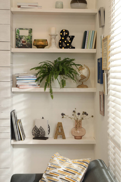 Beautiful green plant and different decor on shelves in room. Interior design - 写真・画像