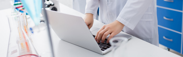 przycięty widok naukowca piszącego na laptopie w laboratorium biologicznym, baner - Zdjęcie, obraz