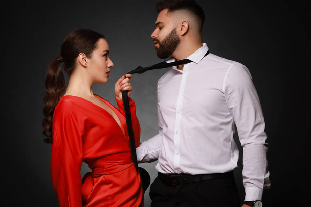 Handsome bearded man with sexy lady on dark background - Фото, изображение