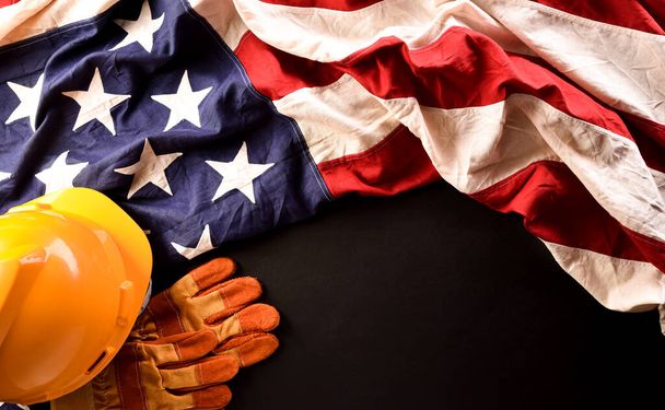 Feliz concepto del Día del Trabajo. Bandera americana con diferentes herramientas de construcción sobre fondo de piedra oscura. - Foto, Imagen