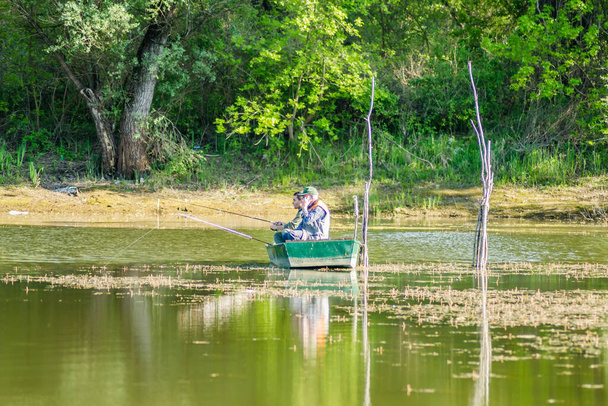 Novi Sad, Serbia - August 17. 2019: Fishermen in a boat on the lake near Novi Sad - 写真・画像
