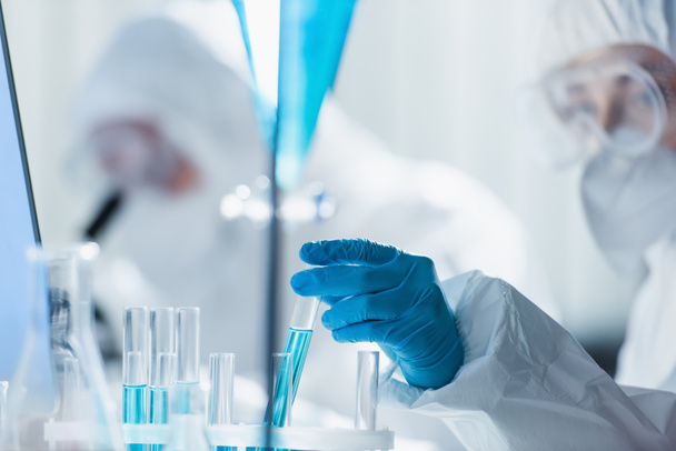 blurred bioengineer in latex glove working with test tubes in laboratory - Photo, Image