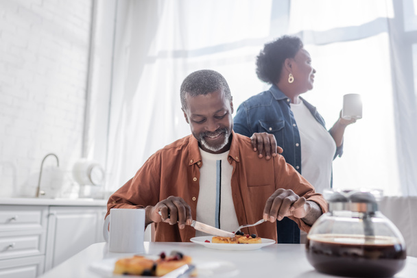 senior african american man having breakfast near happy wife - Fotó, kép