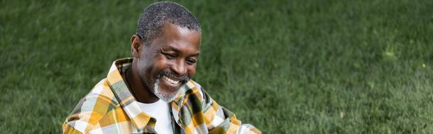 happy senior african american man smiling in park, banner - 写真・画像