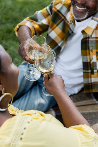 high angle view of senior african american couple clinking glasses of wine - Φωτογραφία, εικόνα