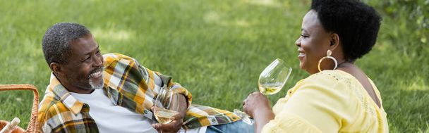 gai et senior couple afro-américain boire du vin pendant le pique-nique, bannière - Photo, image