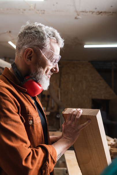 diseñador de muebles positivos en gafas de control de tablón de madera en el taller - Foto, Imagen