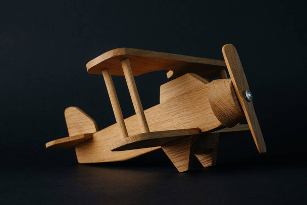 airplane. handmade wooden toy on black background - Foto, imagen