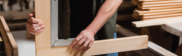 partial view of furniture designer measuring wooden details with corner ruler, banner - Photo, Image