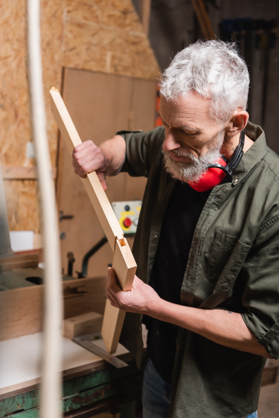 γενειοφόρος ξυλουργός που συνδέει ξύλινες λεπτομέρειες σε στούντιο ξυλουργικής - Φωτογραφία, εικόνα