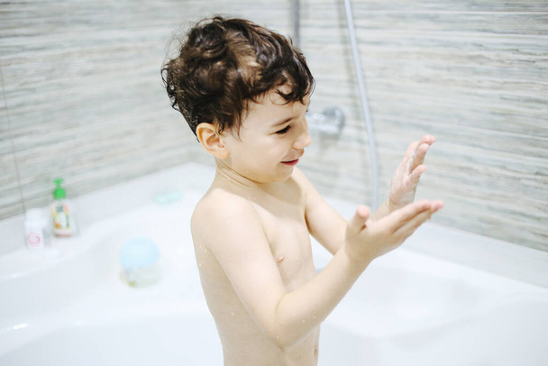 A little boy bathes in a bath. Personal hygiene in childhood. - Fotoğraf, Görsel