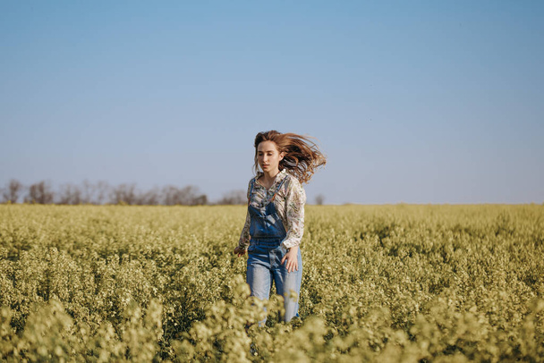 joyful girl running through flowering field - 写真・画像