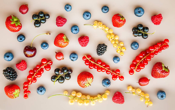 Tasty different ripe fresh summer berries on a neutral background - Foto, afbeelding