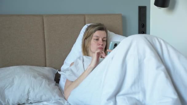 Mujer usando smartphone en la cama, Redes Sociales, Fin de semana perezoso - Metraje, vídeo
